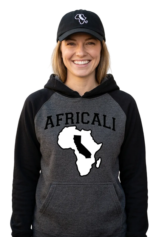 Individual portrait of a smiling white woman wearing the Africali hoodie and embroidered dad hat