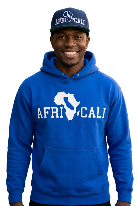 Smiling Black male model wearing the Africali Unity royal blue hoodie and navy snapback
