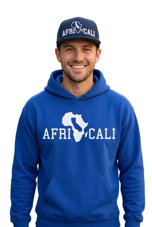 Smiling white male model wearing the Africali Unity royal blue hoodie and navy snapback